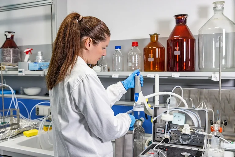 A scientist working in a water quality laboratory with sample bottles